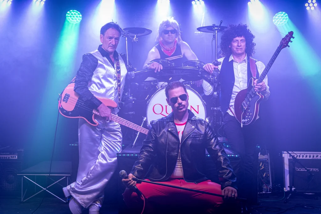 Queen Champions band posing together on stage