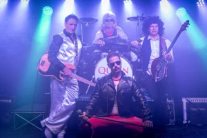 Queen Champions band posing together on stage