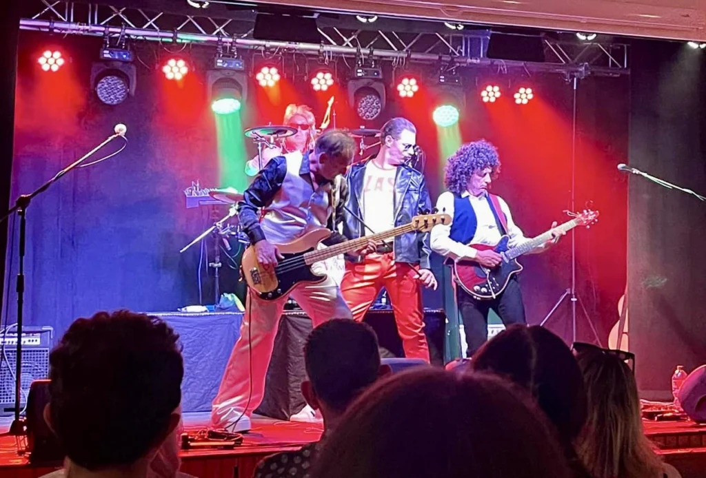 Queen Champions media photo of the full band performing live on stage