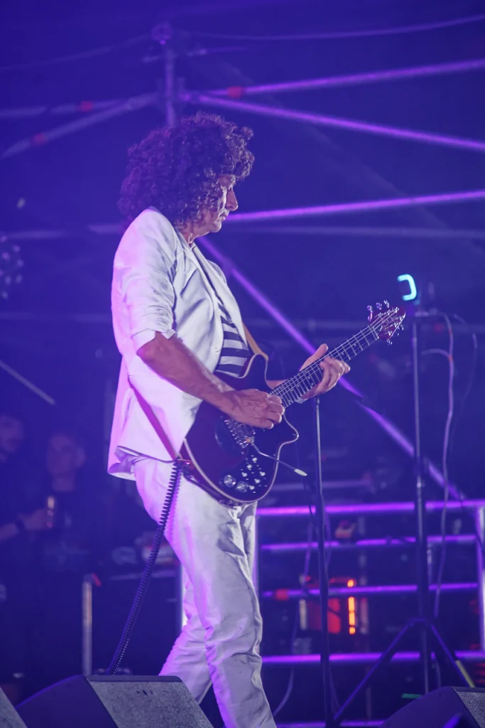 Matt of Queen Champions performing as Brian May under purple stage lighting